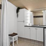 Badezimmer mit Dusche, Waschmaschine und Spiegelschrank.