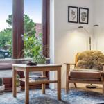 A room with a chair, table, and window to the outdoor terrace.