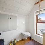 Bathroom with toilet, sink, and window with view.