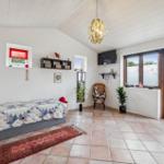 Bedroom with bed, windows, TV, and terrace door.