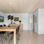 Esszimmer mit Holztisch, schwarzen Stühlen und Deckenlampe.