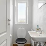 Badezimmer mit Toilette, Waschbecken und Fenster.