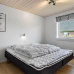 Schlafzimmer mit Bett, Fenster und Wandbild.