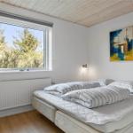 Schlafzimmer mit Doppelbett, Fenster und Gemälde an der Wand.