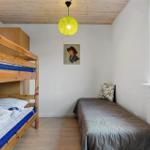 Zimmer mit Doppelstockbett und Einzelbett, Holzdecke, Fenster und Wandbild.