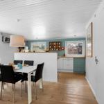 Dining area with table and chairs, kitchen with countertop and windows.