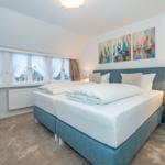 Schlafzimmer mit Bett, Nachttisch und Fenster mit Blick.