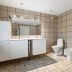 Badezimmer mit Waschbecken, Toilette und Bidet. Fliesen an Wänden und Boden.