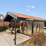 Moderne Holzhütte mit Glasfront, Terrasse und Garten. Sichtbarer Innenraum mit Möbeln.