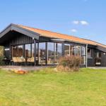 Moderne Holzhütte mit großem Glasbereich und Terrasse im Garten.