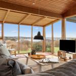 Wohnzimmer mit Holzdecke und großen Fenstern zur Aussicht
