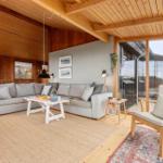 Wohnzimmer mit Sofa, Stuhl und Glasfront zur Terrasse