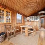 Essbereich mit Holztisch, Stühlen und Glasvitrine an der Wand.