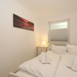 Schlafzimmer mit Bett, Nachttisch und Wandbild