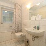 Badezimmer mit Badewanne, WC und Waschbecken.