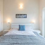 Schlafzimmer mit Bett, Nachttischen und Balkontür.