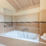 Bad mit Badewanne, Holzdecke und Handtuchstapel