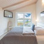 Schlafzimmer mit Bett, Fenster und Wandbildern.