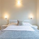 Schlafzimmer mit Doppelbett, Nachttischen und Fensterblick.