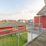 Terrasse mit Blick auf rote und blaue Häuser im Hintergrund.