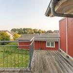 Terrasse mit Blick auf grüne Wiesen und rote Häuser.