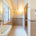 Bad mit Dusche, Waschbecken und Heizkörper