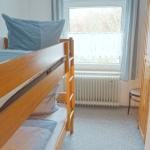 Ein Schlafzimmer mit einem Doppelstockbett, einem Fenster und einem Kleiderschrank.