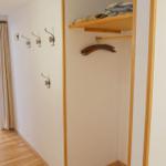 Flur mit Kleiderständer und Haken. Durchgang zum Esszimmer mit Tisch und Stühlen.