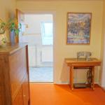 Hausflur mit Holzschrank, Nähmaschine und Bild an der Wand.