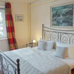 Schlafzimmer mit Bett, Nachttischen und Fenster mit Blick auf Außenbereich.