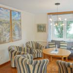 Wohnzimmer mit Sitzgruppe, Tisch und Wandbildern