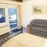 Zimmer mit Bett, Sofa, Fenster und Tür