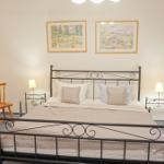 Schlafzimmer mit Bett, Nachttischen, Stühlen und Bildern an der Wand.