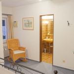 Schlafzimmer mit Blick auf Bad, Wicker-Stuhl und Spiegel