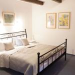 Schlafzimmer mit Bett, Nachttisch und Wandbildern.