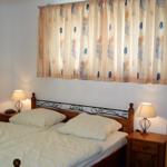 Ein Schlafzimmer mit Doppelbett, zwei Nachttischen und Vorhängen mit Blumenmuster.