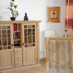 Holzschrank mit Glaseinsätzen und Stuhl mit Muster