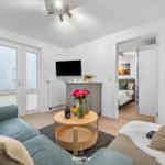 Wohnbereich mit Sofa, Couchtisch und Fernseher. Durchgang zur Schlafzimmer.