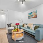 Wohnzimmer mit Sofa, Couchtisch und Wandbild