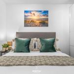 Schlafzimmer mit Bett, Kissen und Wandbild