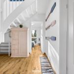 Flur mit Holzboden, Kleiderschrank und Treppe zur oberen Etage.