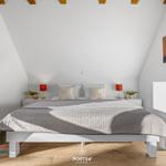 Schlafzimmer mit Dachschrägen, Bett, Nachttischen und Wandbildern.