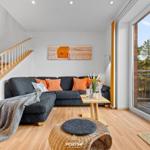 Wohnzimmer mit Sofa, Tisch und Blick auf Balkon.