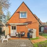 Rotes Backsteinhaus mit Terrasse, Strandkorb und Garten.