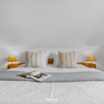 Doppelbett mit Kissen und Bettwäsche, zwei Nachttische mit Lampen, Tür links