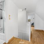 Badezimmer mit Dusche und Toilette. Holzfußboden und Schlafzimmer im Hintergrund.