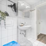 Badezimmer mit Waschbecken, Spiegel und Haartrockner an der Wand.