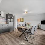 Küche mit Esstisch, Sofa und Fernseher in einem Raum mit Holzboden.