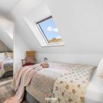 Schlafzimmer mit Dachschrägen, Dachfenster und Spiegelschrank.