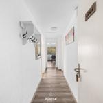 Flur mit Garderobe, Bild und Tür mit Schild Glück.